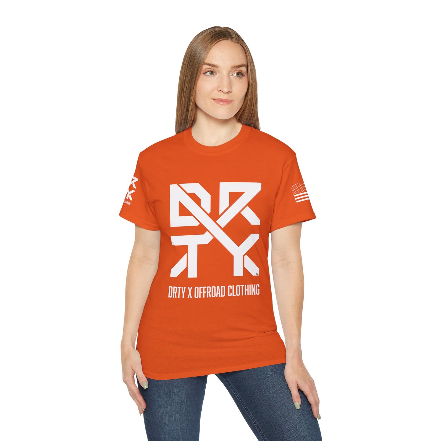 This image showcases the front view of a woman wearing a T-shirt with a DRTY X Logo on the center of the T Shirt and on the right sleeve. The right sleeve has an American flag.