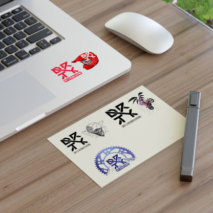 This image shows a small DRTY X logo and artwork sticker on a laptop background and sticker sheet on a table